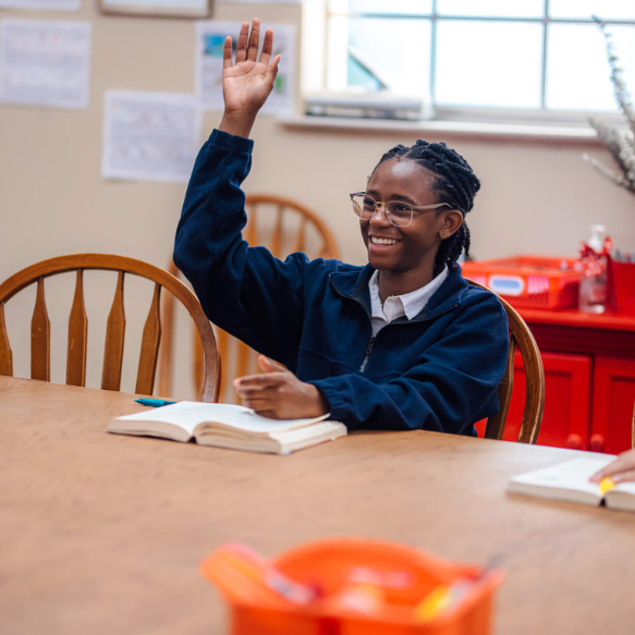 A high school student raising his hand in class at The Dunham School in Baton Rouge, Louisiana.